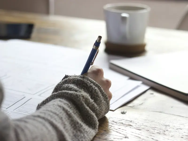 Writer drafting content in a notebook