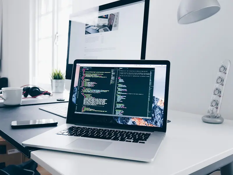 Laptop with website code on a developer's desk